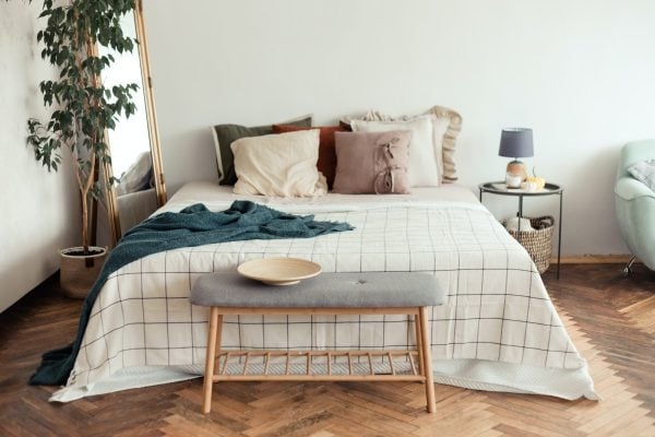 Light bedroom rustic interior with natural materials. Wooden furniture and cotton textiles.